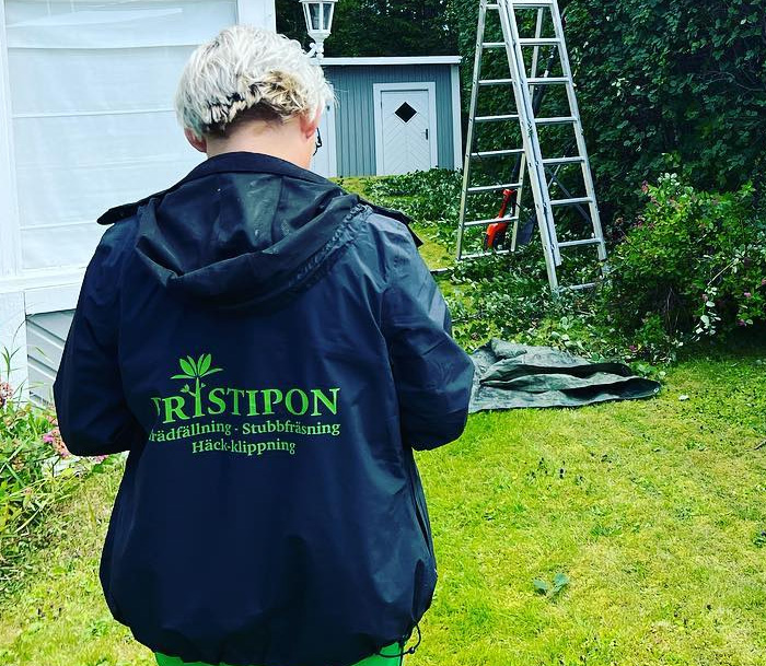 Klipper gräset med en åkgräsklippare åt en bostadsrättsförening